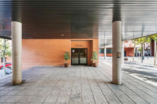 a building with two potted plants in front of it at Sercotel de los Reyes in San Sebastián de los Reyes