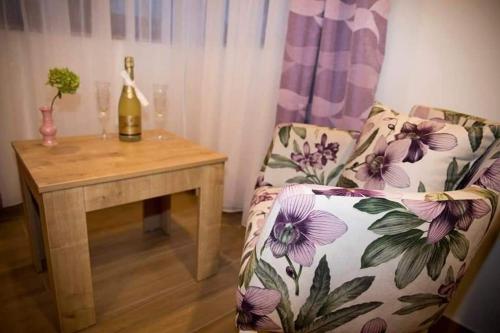 a living room with a couch and a table with a bottle of wine at Villa Bunski biser in Blagaj