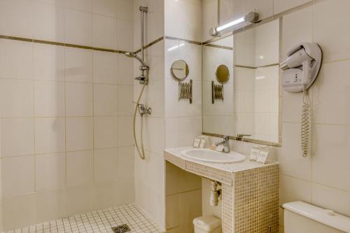 y baño con lavabo y ducha. en Hotel Le Gambetta, en Bergerac