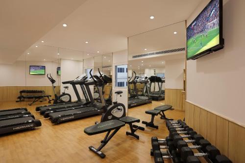 a gym with several tread machines and a flat screen tv at Holiday Inn Express Hyderabad HITEC City by IHG in Hyderabad