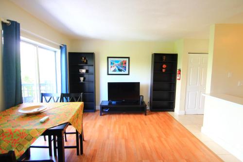 a living room with a table and a television at Sunny Isles Apartments by MiaRentals in Sunny Isles Beach