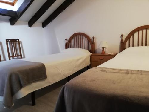 a bedroom with two beds and a table with a lamp at AT Villa Manola in Colombres