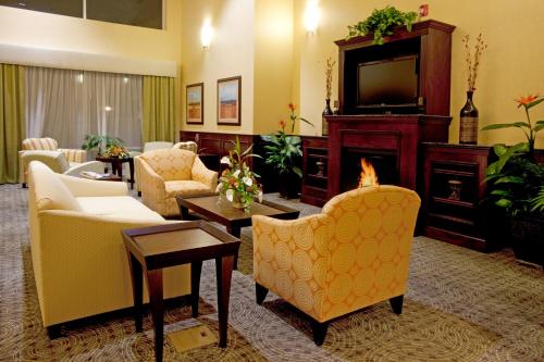 a living room filled with furniture and a tv at Holiday Inn Express Hotel & Suites Chaffee - Jacksonville West, an IHG Hotel in Jacksonville
