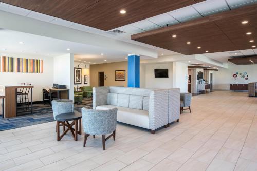 a lobby of a hospital with chairs and tables at Holiday Inn Express & Suites Ludington by IHG in Ludington
