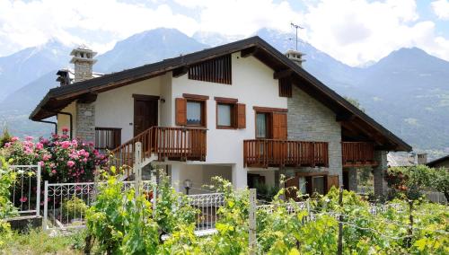 ein Haus mit Balkon und Bergen im Hintergrund in der Unterkunft Rose Apartment in Aosta