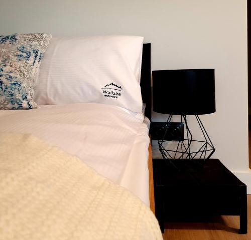 a bed with a white pillow and a television at Walizka Wspomnień in Karpacz