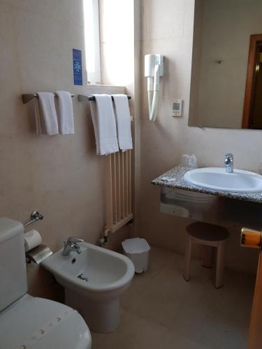 a bathroom with a sink and a toilet and a mirror at Hotel Nordeste Shalom in Bragança