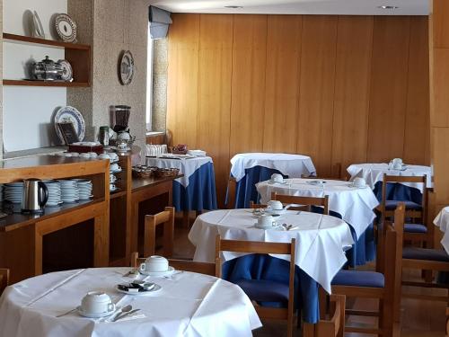 a dining room with tables and chairs with white table cloth at Hotel Nordeste Shalom in Bragança