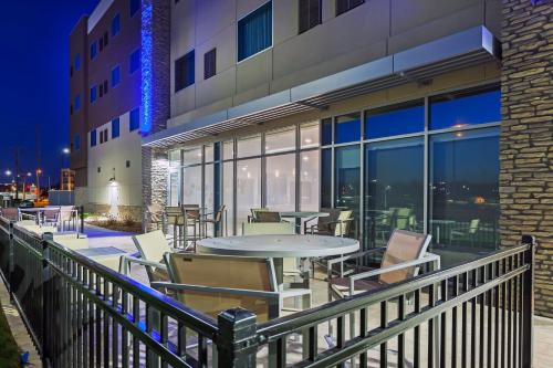 un balcone con tavoli e sedie in un edificio di Holiday Inn Express & Suites - Lenexa - Overland Park Area by IHG a Lenexa