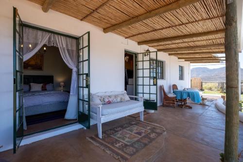 ein Schlafzimmer mit einem Bett und einem Tisch in der Unterkunft 360on62 Farm Cottages in Montagu