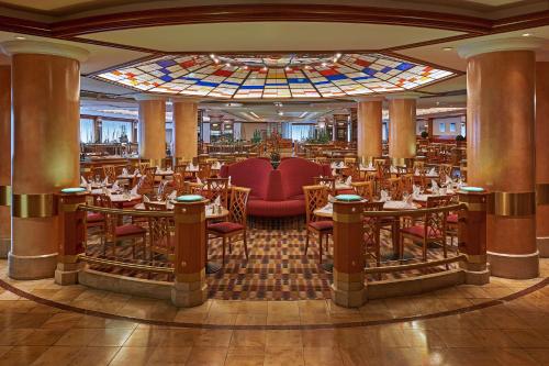 a restaurant with tables and chairs and a stained glass ceiling at Park Inn by Radisson Berlin Alexanderplatz in Berlin