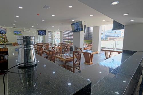 un restaurante con mesas y sillas y una encimera en Hotel ANB Aeropuerto Guadalajara, en Guadalajara
