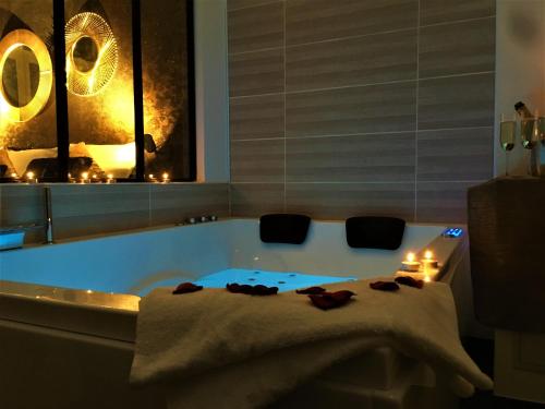 a bathroom with a tub with candles and a towel at GOLD Suite & Spa in Nantes