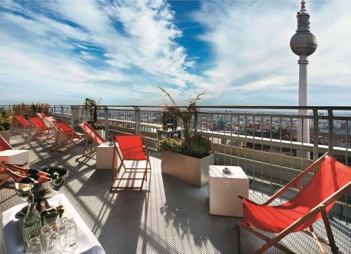a balcony with chairs and a table and a tower at Park Inn by Radisson Berlin Alexanderplatz in Berlin