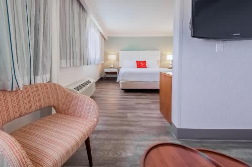una camera d'albergo con letto e sedia di Pasadena Rose & Crown Hotel a Pasadena
