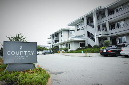 a sign in a parking lot in front of a building at Country Inn & Suites by Radisson, Monterey Beachfront-Marina, CA in Marina