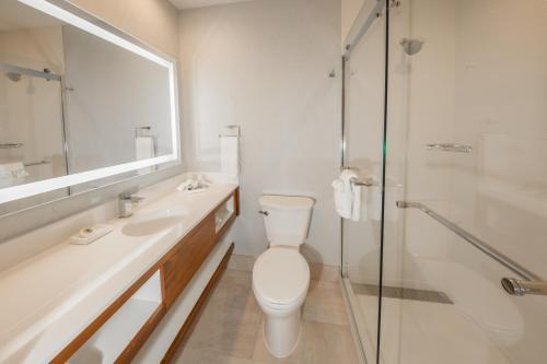 a bathroom with a toilet and a sink and a shower at Pasadena Rose & Crown Hotel in Pasadena