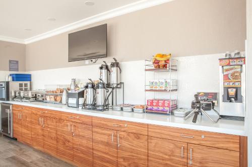 a kitchen with wooden cabinets and a tv on the wall at Pasadena Rose & Crown Hotel in Pasadena