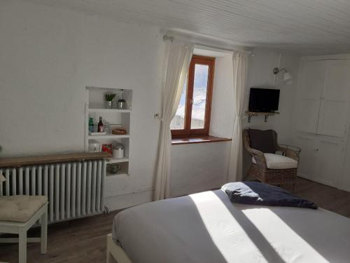 a bedroom with a bed and a window at Bed and Breakfast Les Airelles in Val-des-Prés
