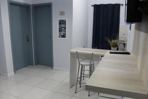 a kitchen with a table and a chair in a room at Hotel e Pousada Magic in Penha