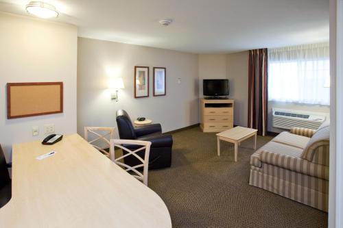 a hotel room with a couch and a living room at Candlewood Suites Minot by IHG in Minot