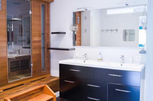 a bathroom with a sink and a shower at Gite La Marjeanerie in Ratières
