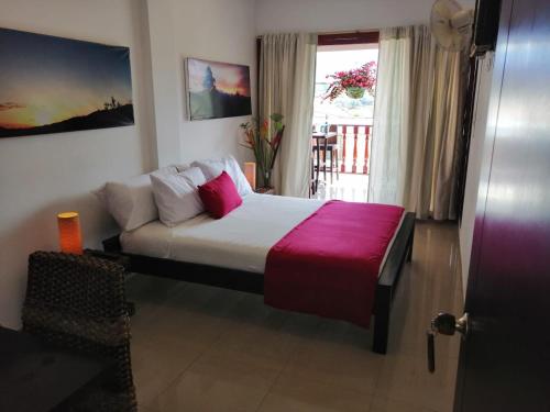 a bedroom with a bed with a couch and a window at Terrazas de San Agustin Hotel in San Agustín
