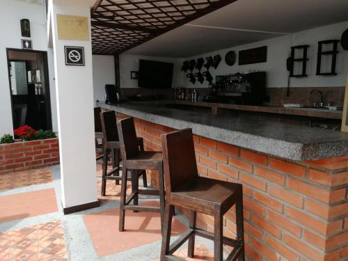 a bar with wooden chairs and a brick counter at Terrazas de San Agustin Hotel in San Agustín