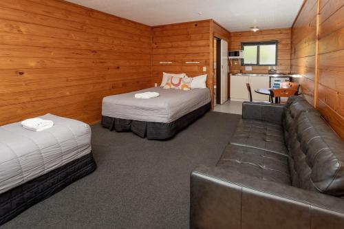 a hotel room with two beds and a couch at Wellington TOP 10 Holiday Park in Lower Hutt