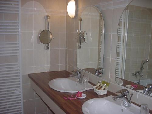 a bathroom with two sinks and a large mirror at Hotel Argi Eder in Aïnhoa