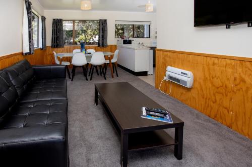 a living room with a couch and a table at Wellington TOP 10 Holiday Park in Lower Hutt