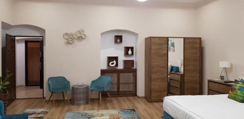 a bedroom with a bed and two blue chairs at IMPERIAL ROOMS - ULTRACENTRAL - jacuzzi cu hidromasaj in Oradea
