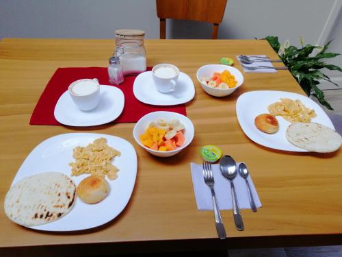 una mesa de madera con platos de comida. en Alicia Hostal Filandia en Filandia