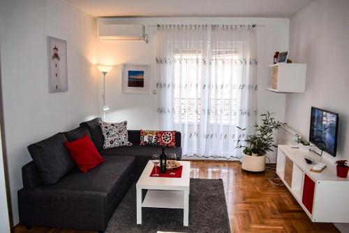 a living room with a black couch and a table at Dunavski Kej in Smederevo
