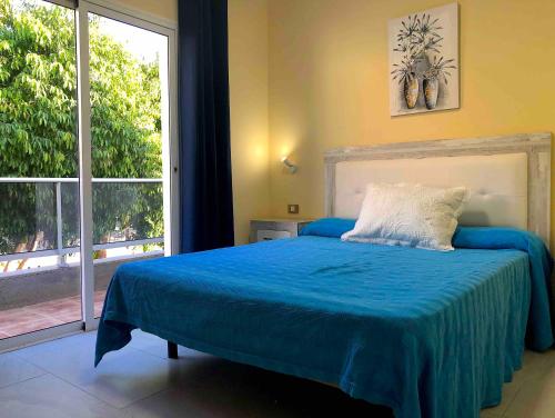 a bedroom with a bed and a large window at Apartamentos La Puntilla Mogan in Puerto de Mogán