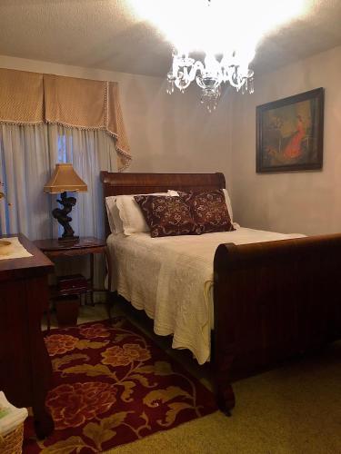 a bedroom with a bed and a chandelier at WINNIE'S BED & BREAKFAST in Lawrenceburg