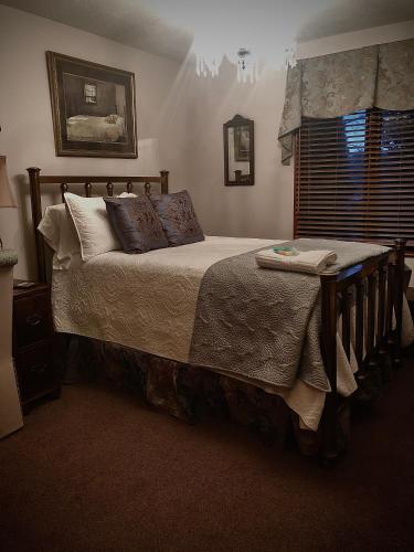 a bedroom with a bed with pillows and a window at WINNIE'S BED & BREAKFAST in Lawrenceburg