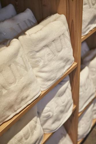 a wooden shelf with white towels on it at Hotel Hubertushof in Saalbach Hinterglemm