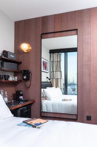 a mirror in a bedroom with a bed and a desk at The Mayson in Dublin