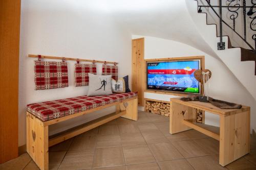 a living room with a tv and a bench and a tv at Appartements Kardona in Ischgl