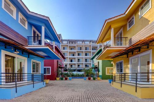 a row of colorful buildings with a building in the background at JAQK Holidays - 9BHK Villa for Big Groups, Private Pool-WiFi-Cartaker-Parking, North Goa in Baga