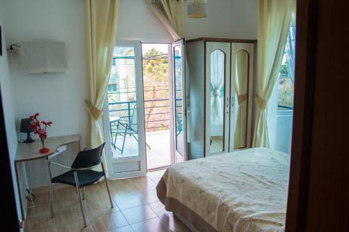 a bedroom with a bed and a desk and a balcony at Residence Coin De Mire in Bain Boeuf