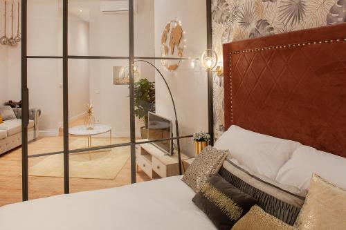 a bedroom with a bed and a living room at MIMA Suites Chueca in Madrid