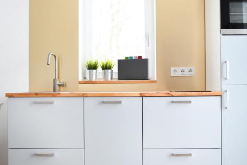 a kitchen with white cabinets and a sink at AllgäuLiebe in Oy-Mittelberg