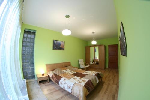 a bedroom with a bed in a room with green walls at uMarka Zeta Park in Ustroń