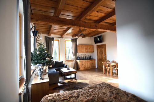 een woonkamer met een kerstboom in het midden bij Apartamenty Rogowcówka in Biały Dunajec