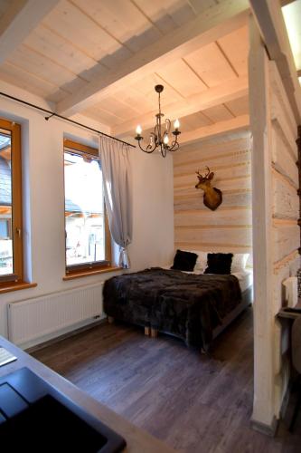 a bedroom with a bed and a chandelier at Apartamenty Rogowcówka in Biały Dunajec