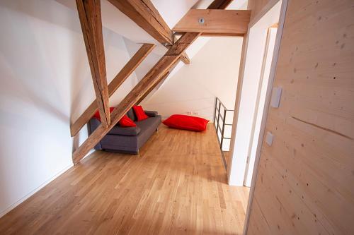 a attic room with a couch and a red pillow at Historisches Wohnen modern interpretiert in Kirrweiler