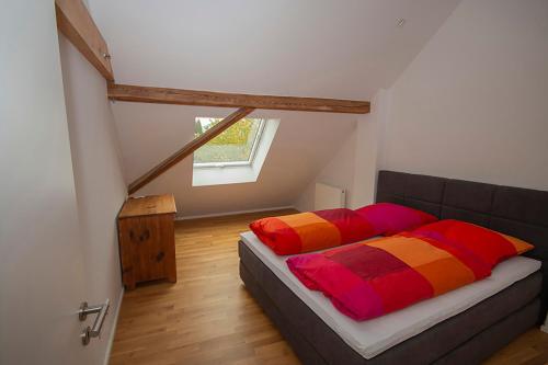 a bedroom with a bed with colorful pillows on it at Historisches Wohnen modern interpretiert in Kirrweiler