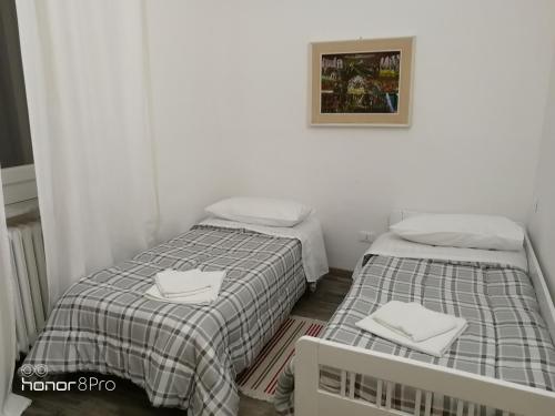 two beds in a small room with white walls at Casa Viorica in Ancona
